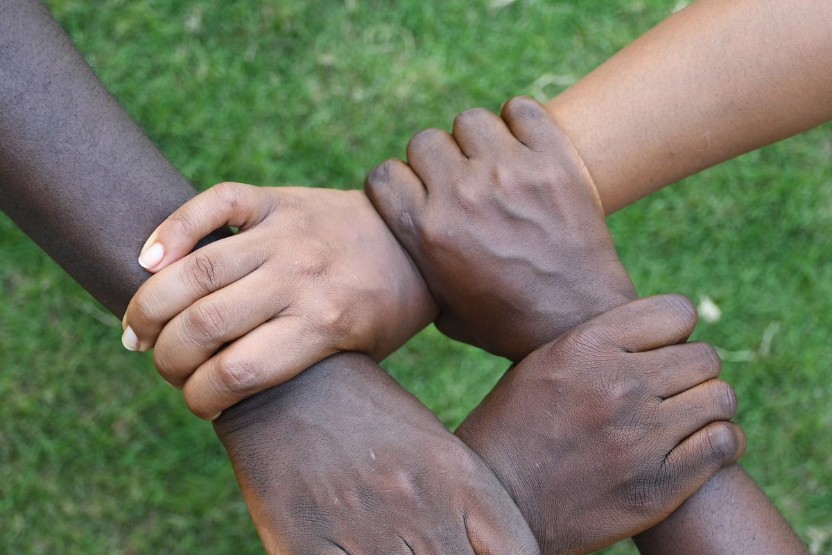 Four hands clasped together, representing a trusted partnership